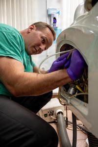 U.S. Air Force Tech. Sgt. Jonathan Rousseau, 920th Aeromedical Staging Squadron biomedical equipment technician, repairs a waterline on a dental chair at the Cheddi Jagan Dental School in Georgetown, Guyana, March 19, 2026. BMET teams helped restore critical medical equipment across Guyana as part of the Lesser Antilles Medical Assistance Team 2026 mission, a U.S. Air Forces Southern-led health security cooperation engagement that brings U.S. and partner-nation medical professionals together to deliver care and strengthen regional health capacity. (U.S. Air Force photo by Maj. Stephani Schafer)