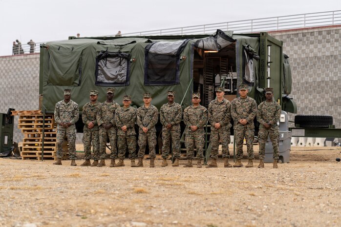 U.S. Marines with Food Service Company, Combat Logistics Regiment 37, 3rd Marine Logistics Group, pose for a photo in front of an Expeditionary Field Kitchen during the Korean Marine Exchange Program 26.1 in Camp Mujuk, South Korea, March 25, 2026. KMEP is a semi-annual exercise that provides opportunities for ROK Marine Corps and U.S. Marine Corps units to train together, improving their combined capabilities to deter threats and maintain peace on the Korean Peninsula. (U.S. Marine Corps photo by 1st Lt. Taiyo Tatara)