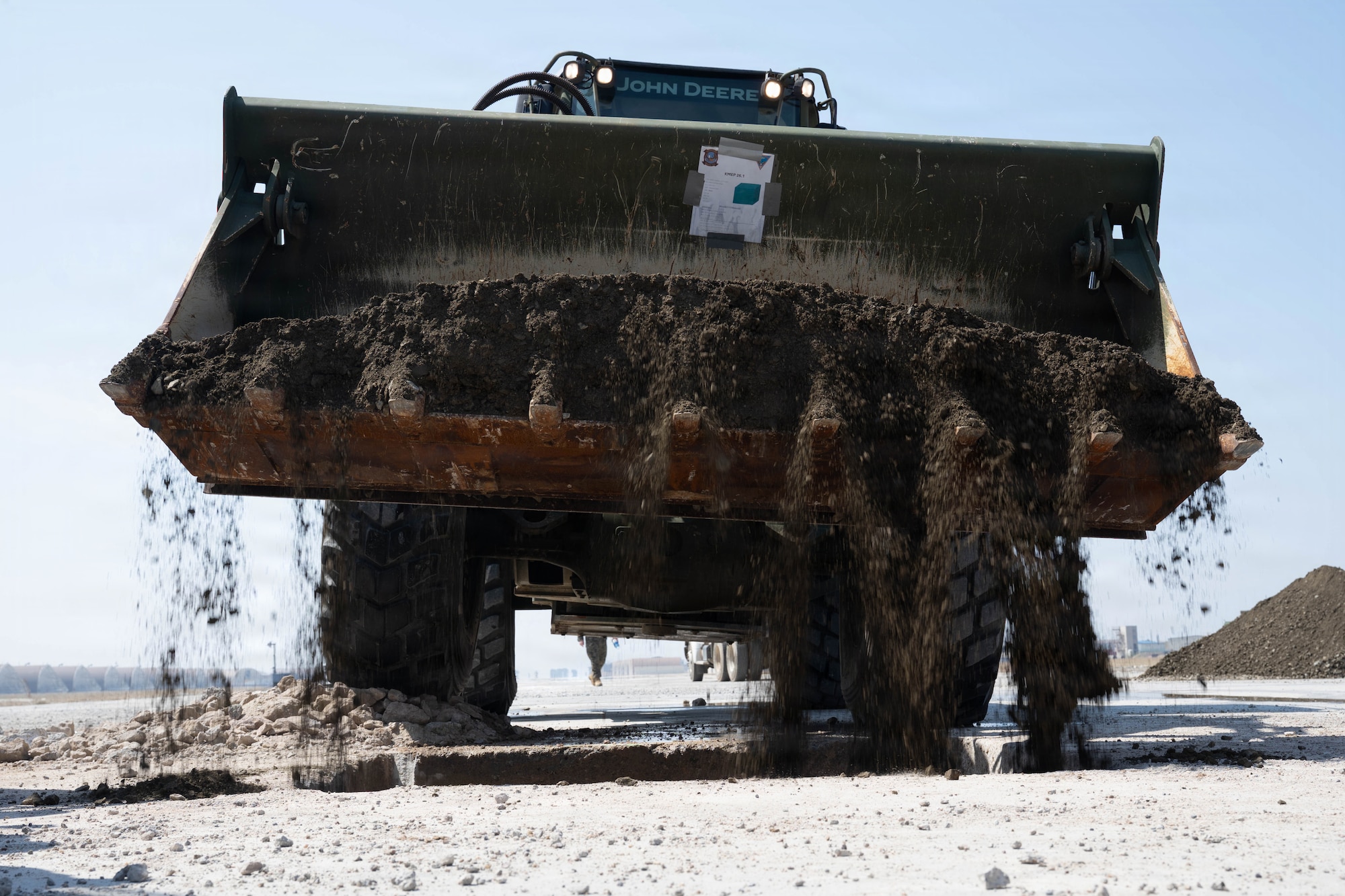 A bulldozer fills a crater with dirt.