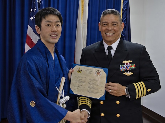YOKOSUKA, Japan (March 20, 2026) — Capt. Donavon YapShing, deputy director of U.S. Naval Hospital Yokosuka, presents a diploma to Dr. Sho Nonoyama during the Japanese National Physician Postgraduate Education Program graduation ceremony. U.S. Naval Hospital Yokosuka graduated six physicians from the yearlong program, strengthening bilateral medical readiness and patient care across the Indo-Pacific. (U.S. Navy photo by Daniel Taylor/USNMRTC Yokosuka Public Affairs)