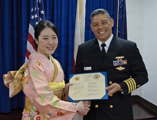 YOKOSUKA, Japan (March 20, 2026) — Capt. Donavon YapShing, deputy director of U.S. Naval Hospital Yokosuka, presents a diploma to Dr. Reika Matsushita during the Japanese National Physician Postgraduate Education Program graduation ceremony. U.S. Naval Hospital Yokosuka graduated six physicians from the yearlong program, strengthening bilateral medical readiness and patient care across the Indo-Pacific. (U.S. Navy photo by Daniel Taylor/USNMRTC Yokosuka Public Affairs)