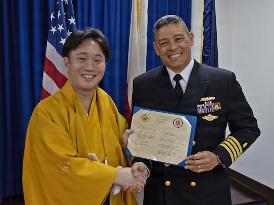 YOKOSUKA, Japan (March 20, 2026) — Capt. Donavon YapShing, deputy director of U.S. Naval Hospital Yokosuka, presents a diploma to Dr. Takehiro Mochizuki during the Japanese National Physician Postgraduate Education Program graduation ceremony. U.S. Naval Hospital Yokosuka graduated six physicians from the yearlong program, strengthening bilateral medical readiness and patient care across the Indo-Pacific. (U.S. Navy photo by Daniel Taylor/USNMRTC Yokosuka Public Affairs)