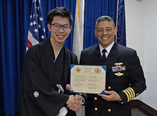 YOKOSUKA, Japan (March 20, 2026) — Capt. Donavon YapShing, deputy director of U.S. Naval Hospital Yokosuka, presents a diploma to Dr. Tomonari Shimoda during the Japanese National Physician Postgraduate Education Program graduation ceremony. U.S. Naval Hospital Yokosuka graduated six physicians from the yearlong program, strengthening bilateral medical readiness and patient care across the Indo-Pacific. (U.S. Navy photo by Daniel Taylor/USNMRTC Yokosuka Public Affairs)