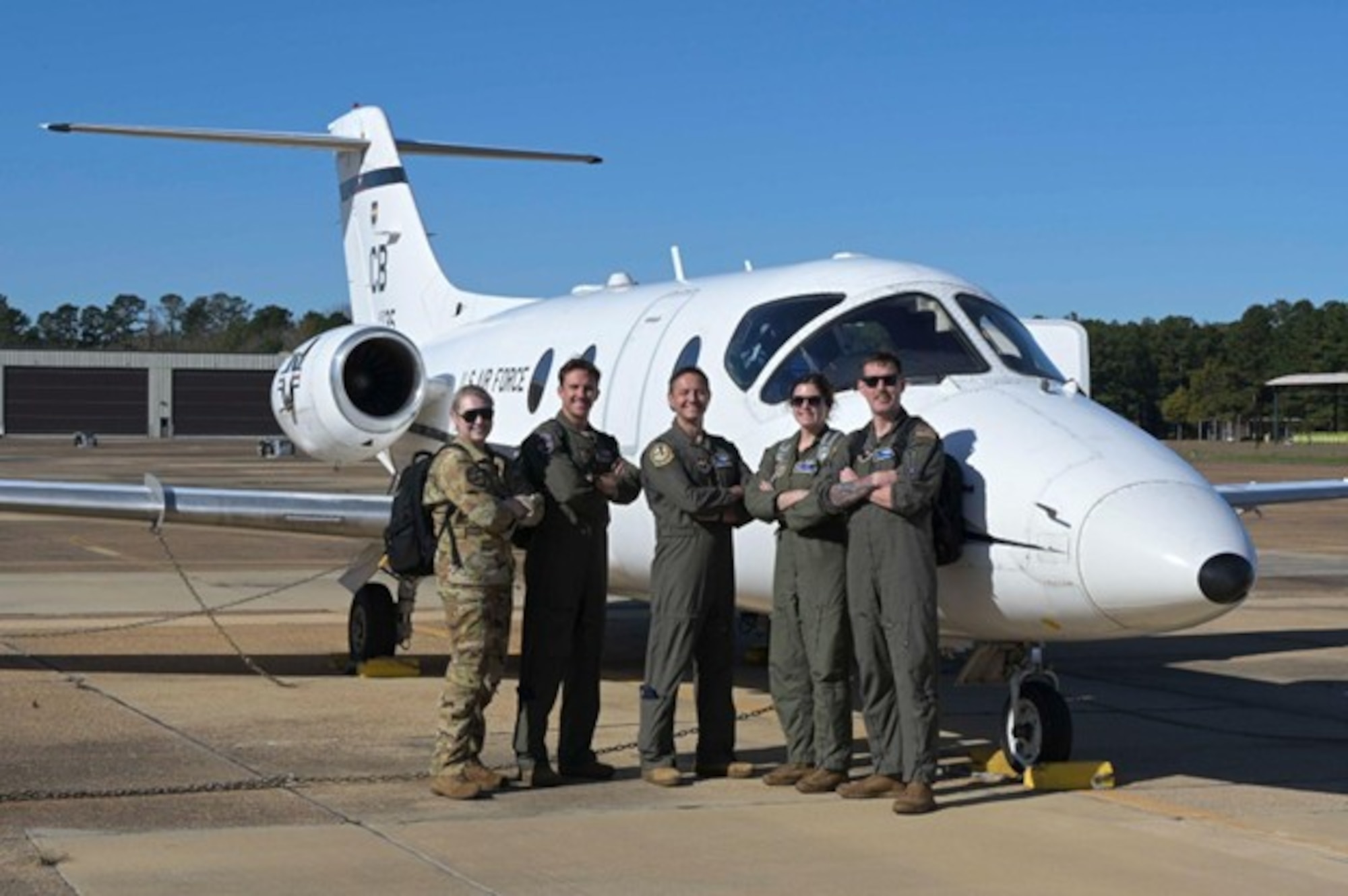 U.S. Air Force Airmen assigned to the 48th Flying Training Squadron pose for a photo in front of a T-1A Jayhawk at Columbus Air Force Base, Nov. 26, 2025.