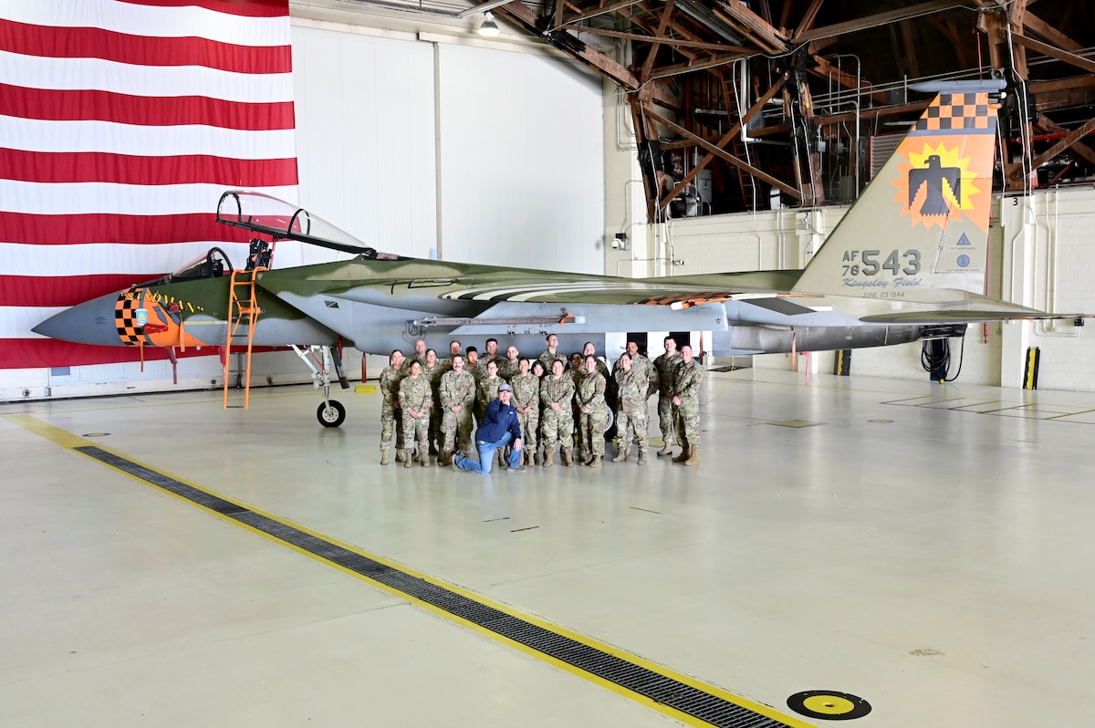 People pose for a picture in front of an F-15