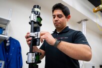 Kevin Marquez-Diaz, U.S. Naval Research Laboratory (NRL) materials engineer, attaches a smartphone to a fuel safe, explosion proof version of the Insertable Stalk Inspection System (ISIS) for remote image capturing in Washington, D.C., March 3, 2026. NRL developed this digital corrosion inspection device to improve the safety, speed, and accuracy of shipboard tank inspections within the Navy. (U.S. Navy photo by Sarah Peterson) RELEASED