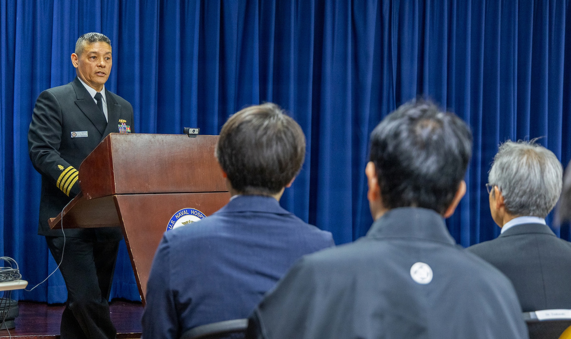 YOKOSUKA, Japan (March 20, 2026) — Capt. Donavon YapShing, deputy director of U.S. Naval Hospital Yokosuka, delivers remarks during the Japanese National Physician Postgraduate Education Program graduation ceremony. U.S. Naval Hospital Yokosuka graduated six physicians from the yearlong program, strengthening bilateral medical readiness and patient care across the Indo-Pacific. (U.S. Navy photo by Daniel Taylor/USNMRTC Yokosuka Public Affairs)