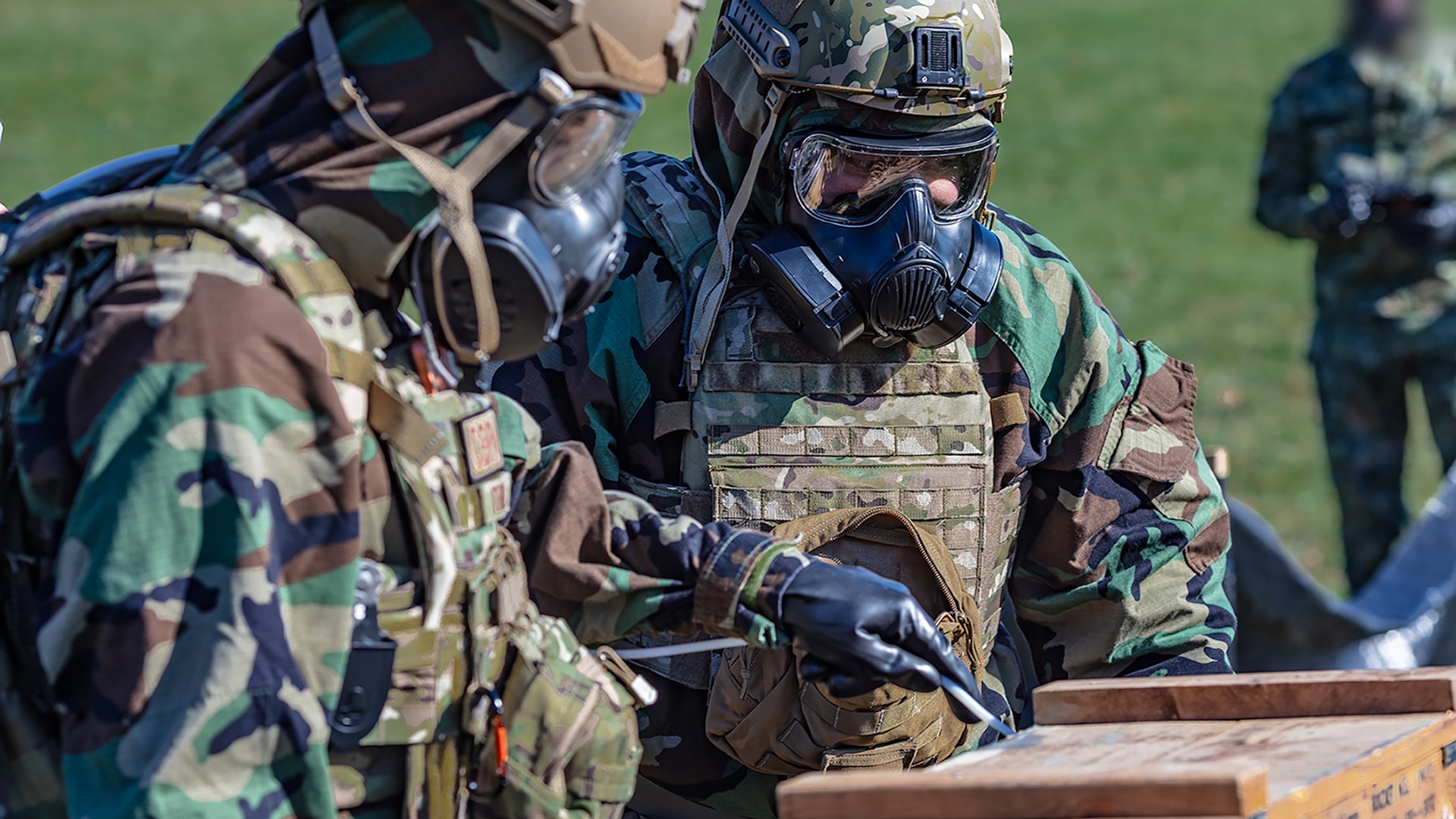 Military Personnel using testing kits in full mopp suits