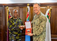 Adm. George Wikoff and General Charles Kahariri exchange gifts at the Defence Headquarters in Nairobi.