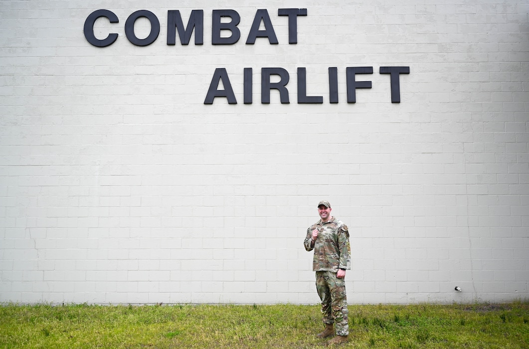 Man poses in front of wall.