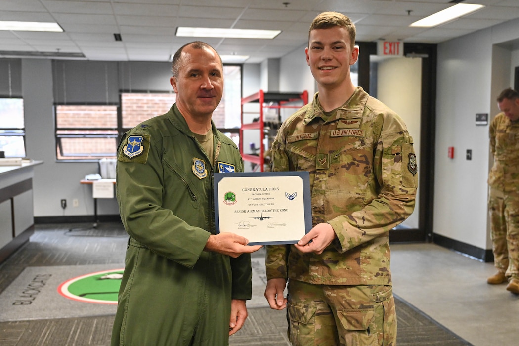 Two men pose with a certificate.
