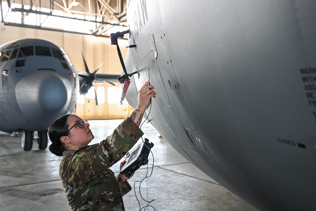 Woman inspects plane.