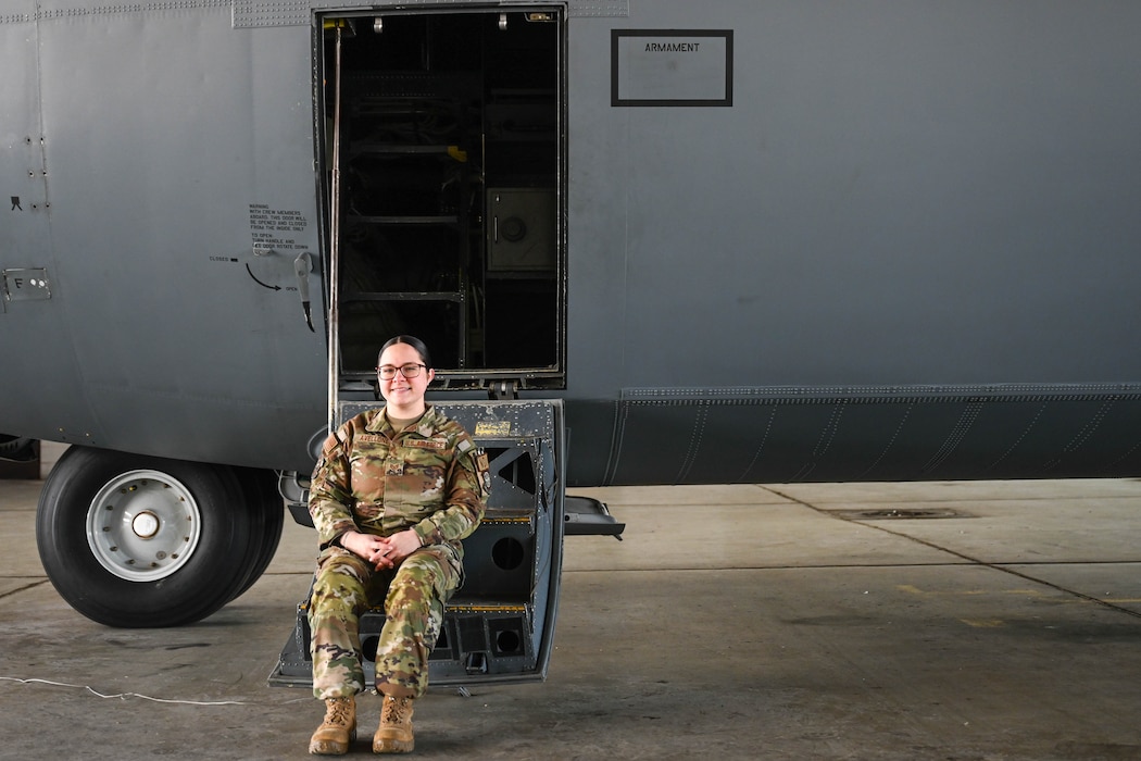 Woman poses on steps of plane.