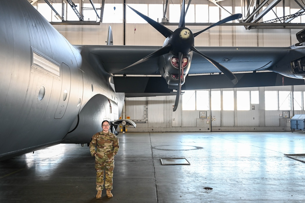 Woman poses next to plane.