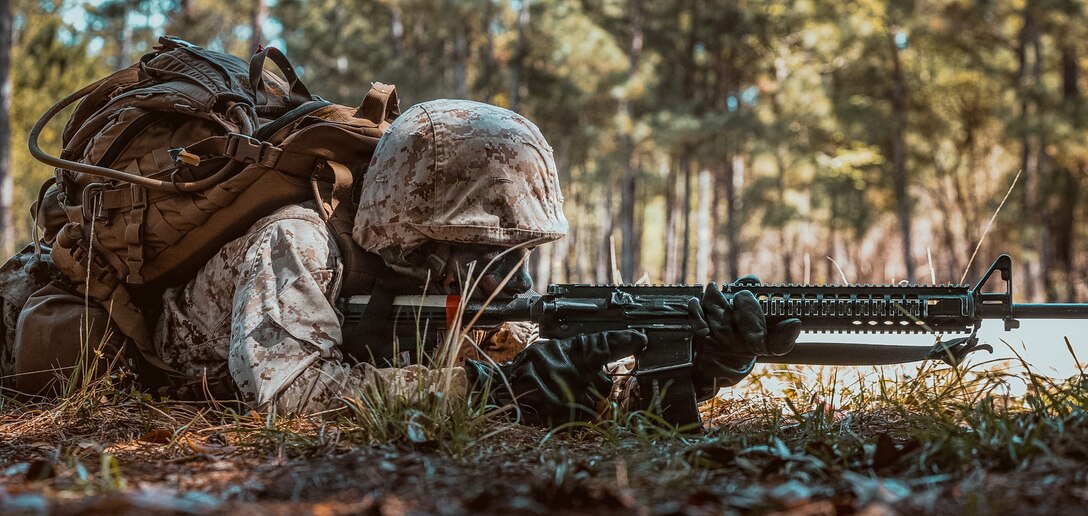 A Marine holds a rifle outside during training