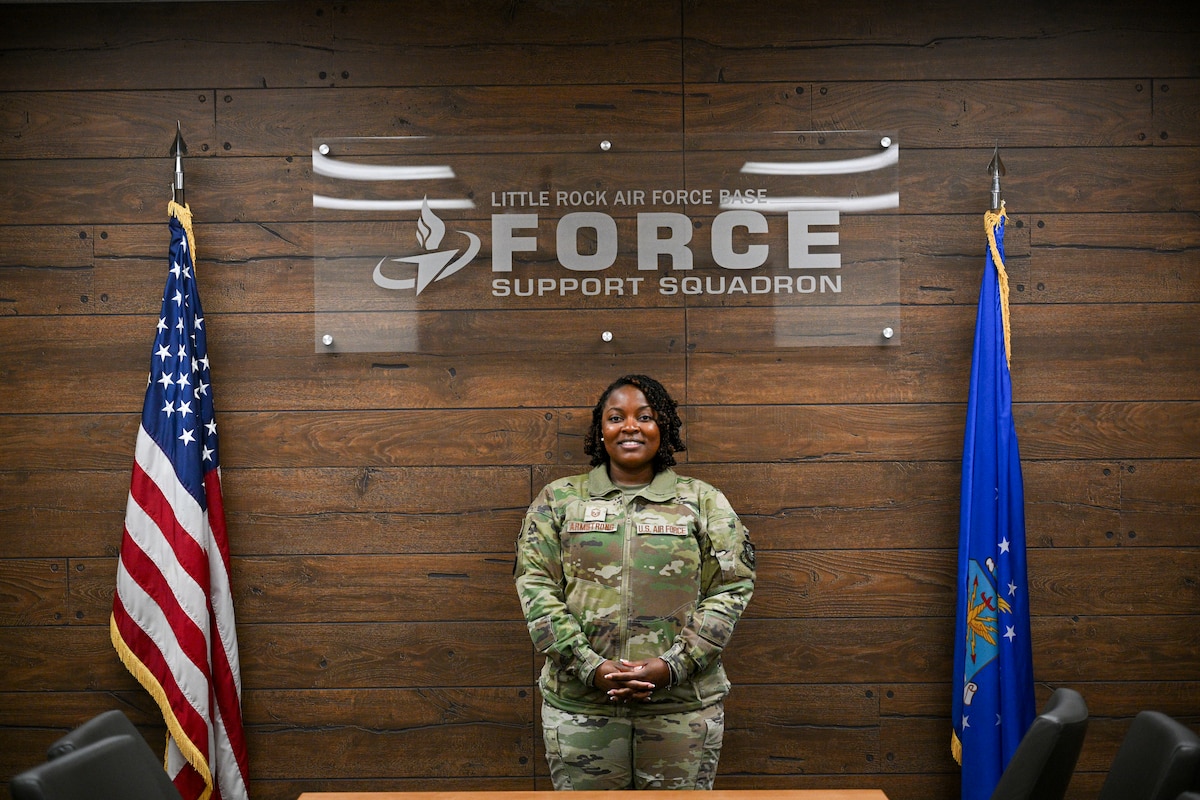 Woman poses between two flags.