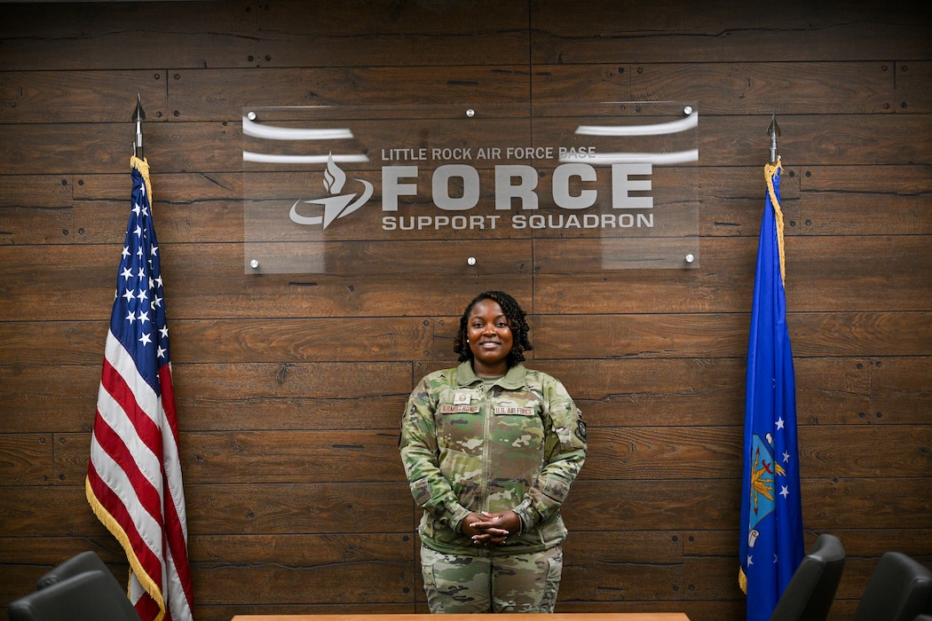 Woman poses between two flags.