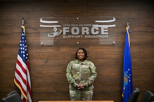 Woman poses between two flags.
