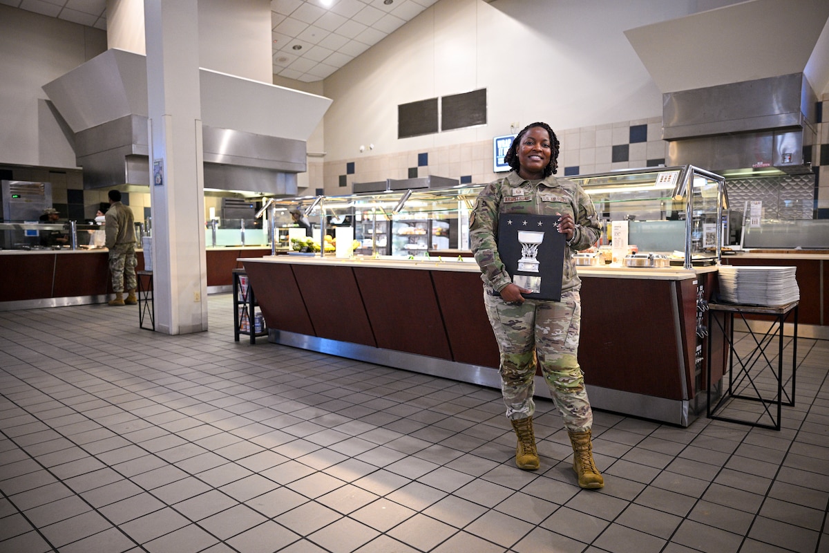 Woman poses with a plaque.