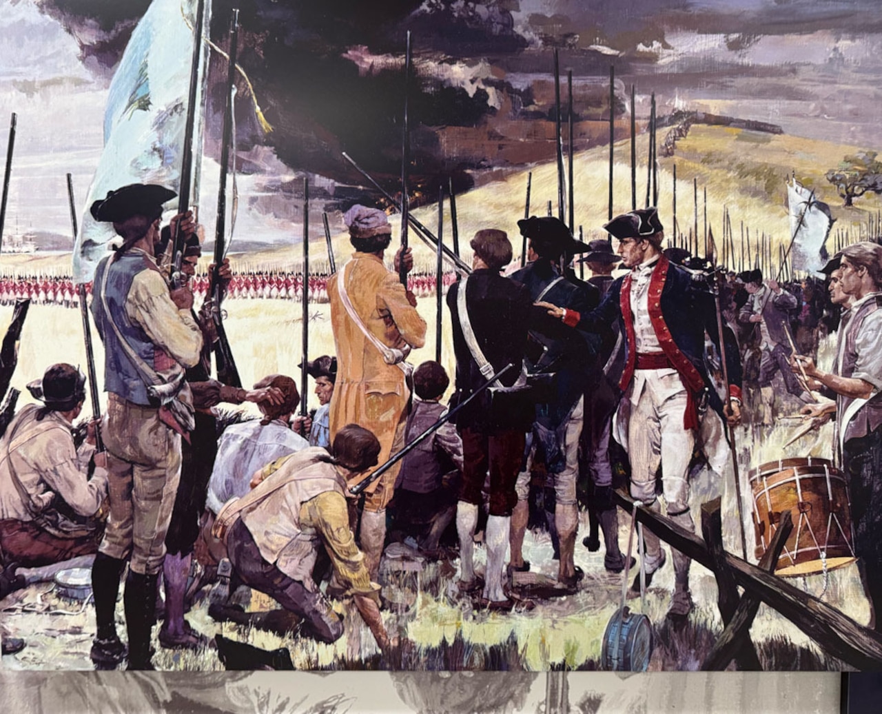 Men in a variety of Revolutionary War-era military uniforms wield muskets, play a drum and carry flags.