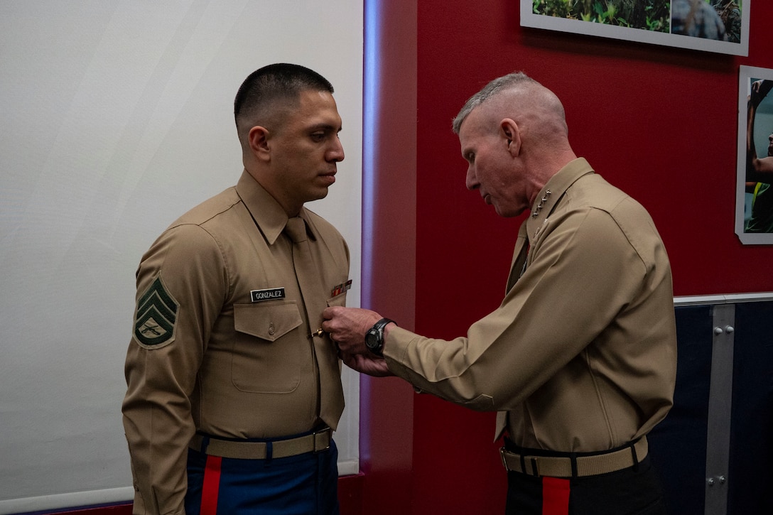The 39th Commandant of the Marine Corps, Gen. Eric M. Smith, presents a Navy Commendation Medal to Staff Sgt. Gilberto Gonzalez, Recruiting Sub-Station Hollywood station commander, during a visit to Recruiting Sub-Station Ventura in Ventura, California, Dec. 5, 2025. Smith visited the station while in Los Angeles for the Reagan National Defense Forum. (U.S. Marine Corps photo by Sgt. Michele Clarke)