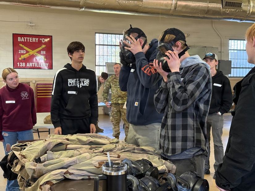 Students don protective masks during a timed event to apply Mission-Oriented Protective Posture (MOPP) gear during a cumulative skills challenge at a job shadow event in Bardstown, Kentucky, March 24.