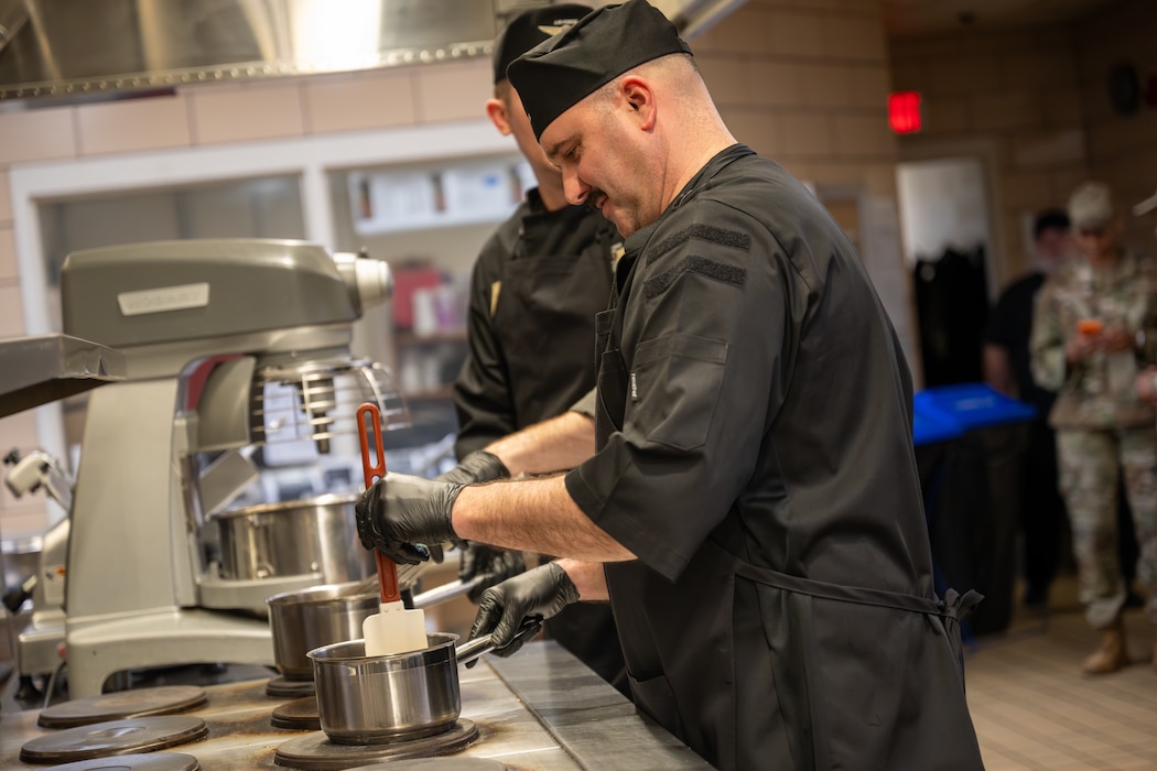 U.S. Air Force Chief Master Sgt. Jonny Adams, 97th Air Mobility Wing command chief, stirs sauce during a “Boots on the Ground” cooking competition at Altus Air Force Base, Oklahoma, March 23, 2026. Members of the command team worked alongside Airmen from the 97th Force Support Squadron to prepare meals as part of an immersion tour. (U.S. Air Force photo by Airman 1st Class Nathan Langston)
