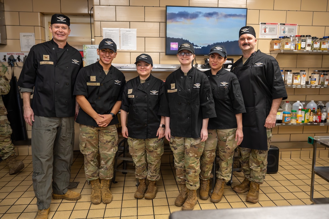 The U.S. Air Force 97th Air Mobility Wing command team poses with Airmen from the 97th Force Support Squadron for a group photo at Altus Air Force Base, Oklahoma, March 23, 2026. The photo was taken following the 97th Force Support Squadron’s “Boots on the Ground” immersion tour, which gave the command team a firsthand look at Hangar 97 dining facility operations. (U.S. Air Force photo by Airman 1st Class Nathan Langston)