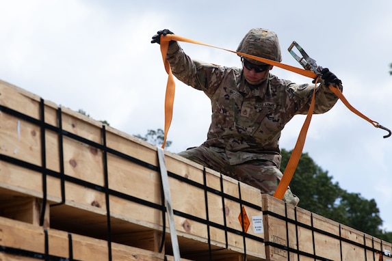 U.S. Army Staff Sgt. Andrew McLeod, a motor sergeant with the Thomasville-based 1230th Transportation Company, 110th Combat Sustainment Support Battalion, 78th Troop Command, Georgia Army National Guard, tightens down a pallet of ammunition on a trailer during Operation Patriot Press 2024 July 17, 2024, at the Anniston Army Depot, Anniston, Alabama. This exercise, established by the Army Materiel Command, is designed to promote readiness by providing real-world training for Army requirements and to achieve training towards Mission Essential Task requirements for Army active duty, Army Reserve, National Guard, and various other service branches. (U.S. Army National Guard photo by Sgt. 1st Class James Braswell)