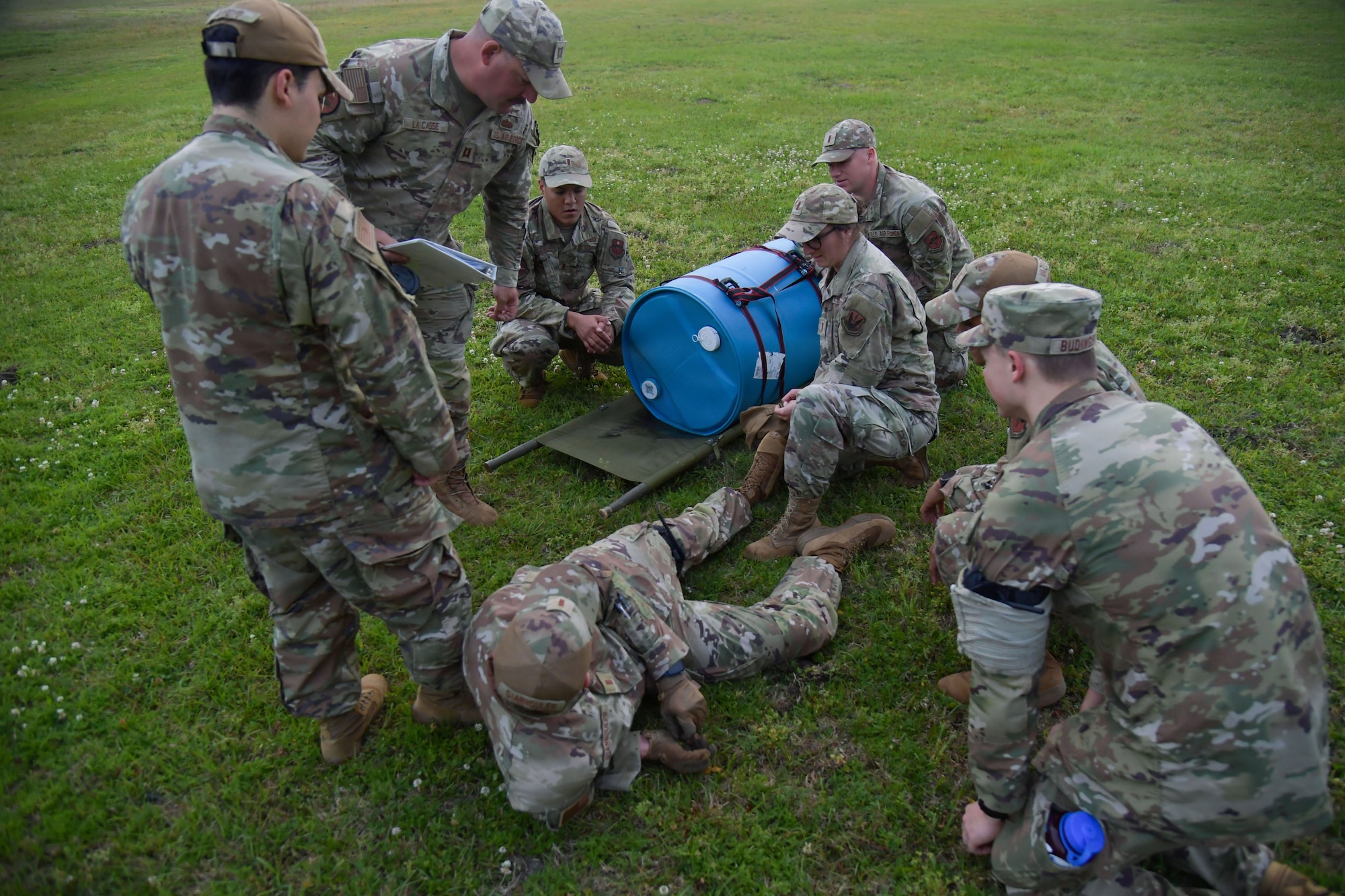 A group of people in military uniform stand around in a huddle.