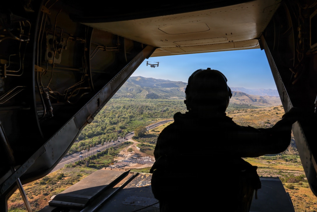 U.S. Marine Corps Lance Cpl. Alexander Marquez, a crew chief with Marine Medium Tiltrotor Squadron (VMM) 165, Marine Aircraft Group 39, 3rd Marine Aircraft Wing, observes flight operations from the back of an MV-22B Osprey in support of a deployment readiness air confidence operation conducted at Marine Corps Base Camp Pendleton, California, March 24, 2026.