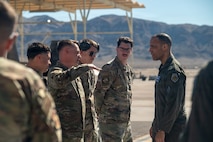 Airmen line up in a row to speak with Gen. Adiran Spain as Gen. Spain looks to them.