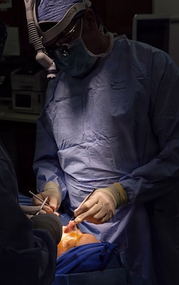YOKOSUKA, Japan (March 9, 2026) —  Capt. Matthew Keller, an ear, nose and throat and facial plastic surgeon assigned to U.S. Naval Hospital (USNH) Yokosuka performs a functional septorhinoplasty and inferior turbinate reduction under surgical lighting in an operating room. USNH Yokosuka provides forward-deployed surgical capabilities that enhance warfighter readiness and improve patient care across the Indo-Pacific region. (U.S. Navy photo by Daniel Taylor/USNMRTC Yokosuka Public Affairs)