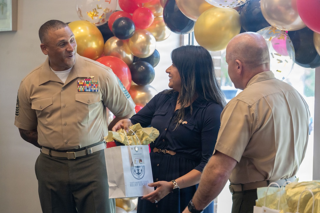 Navy and Marine Corps Relief Society volunteer Ingrid Sanchez receives an award for 600 and 1,000 volunteer hours to the program on Marine Corps Base Camp Lejeune, North Carolina, April 24, 2026. The Navy and Marine Corps Relief Society is a volunteer-led program that specifically aids U.S. Marines and sailors in times of hardship. (U.S. Marine Corps photo by Lance Cpl. Isaac Garza)