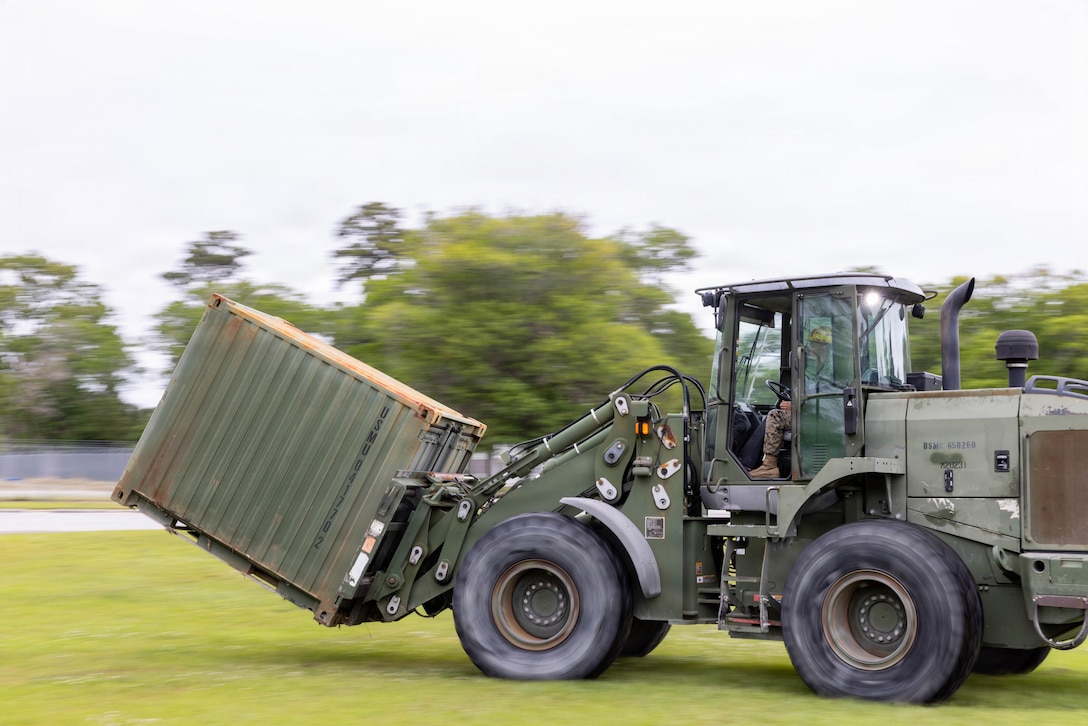 U.S. Marine Corps Lance Cpl. Nicholas Hiebert, an engineer equipment operator with II Marine Expeditionary Force Support Battalion, drives a Tractor Rubber-Tired Articulated Steering Multi-Purpose vehicle during a 2nd Marine Expeditionary Brigade Command and Control (C2) field exercise at Marine Corps Base Camp Lejeune, North Carolina, April 27, 2026. The exercise was designed to validate the C2 constructs to ensure the systems function together properly. (U.S. Marine Corps photo by Lance Cpl. Channah Chilton)