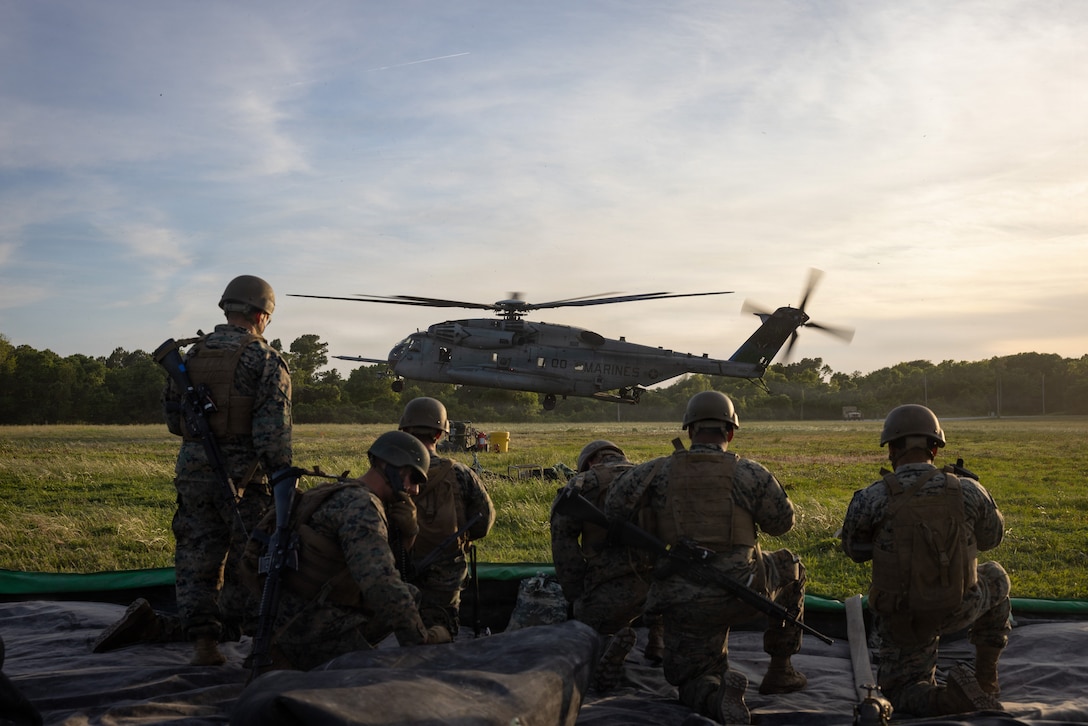 U.S. Marines with 8th Engineer Support Battalion, Combat Logistics Regiment 27, 2nd Marine Logistics Group, prepare to approach a CH-53E Super Stallion assigned to Marine Heavy Helicopter Squadron (HMH) 464, Marine Aircraft Group 29, 2nd Marine Aircraft Wing, during air-ground delivered refueling operations as part of a large multi-modal field exercise at Marine Corps Base Camp Lejeune, North Carolina, April 28, 2026. The purpose of this exercise is to train and evaluate the Marines' ability to provide distributed and expeditionary class III resupply from an expeditionary advanced base. (U.S. Marine Corps photo by Sgt. Rafael Brambila-Pelayo)