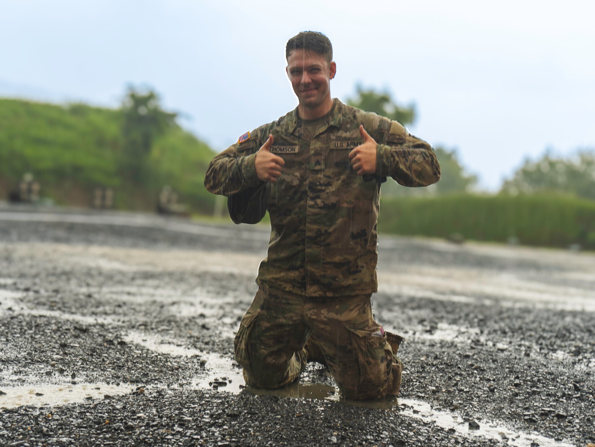 U.S. Army Sgt. David Thomson , assigned to the 109th Mobile Public Affairs Detachment, 213th Regional Support Group, Pennsylvania National Guard, gives a thumbs up while in the mud and rain at a range on Fort Indiantown Gap, Pennsylvania, July 13, 2025. Thomson was recently promoted and is on the media outreach team during this year's annual training. (U.S. Army National Guard photo by Sgt. Ashon Calhoun).