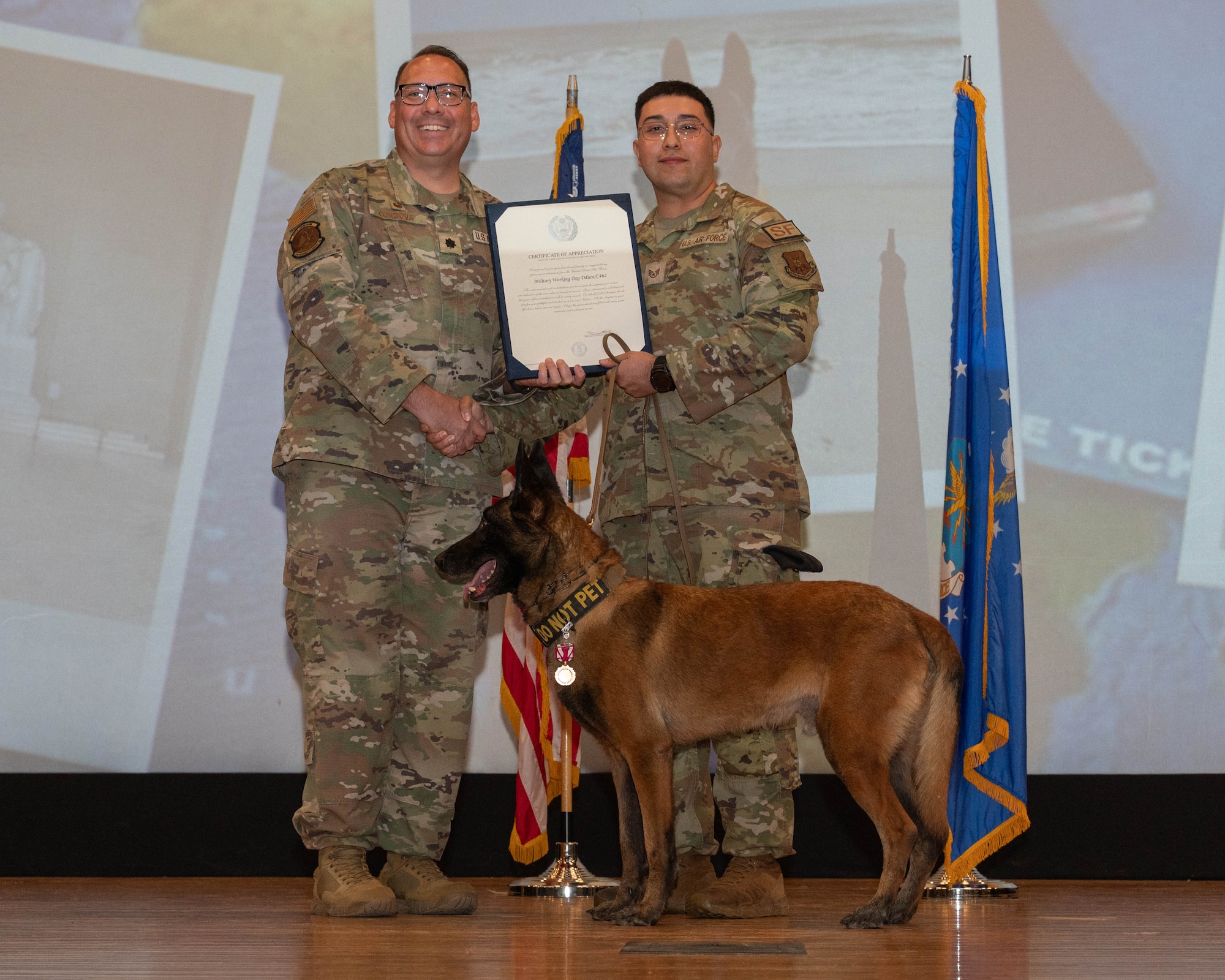 U.S. Air Force Lt. Col. Richard Cordova, 7th Security Forces Squadron commander, presents a certificate of appreciation to Staff Sgt. Christopher Barraza, 7th SFS military working dog handler, for MWD Dduco during a retirement ceremony at Dyess Air Force Base, Texas, April 29, 2026. The certificate recognized Dduco’s four years and six months of dedicated service in patrol and detection operations, contributing to the overall security and safety of Dyess AFB. (U.S. Air Force photo by Airman 1st Class William Neal)