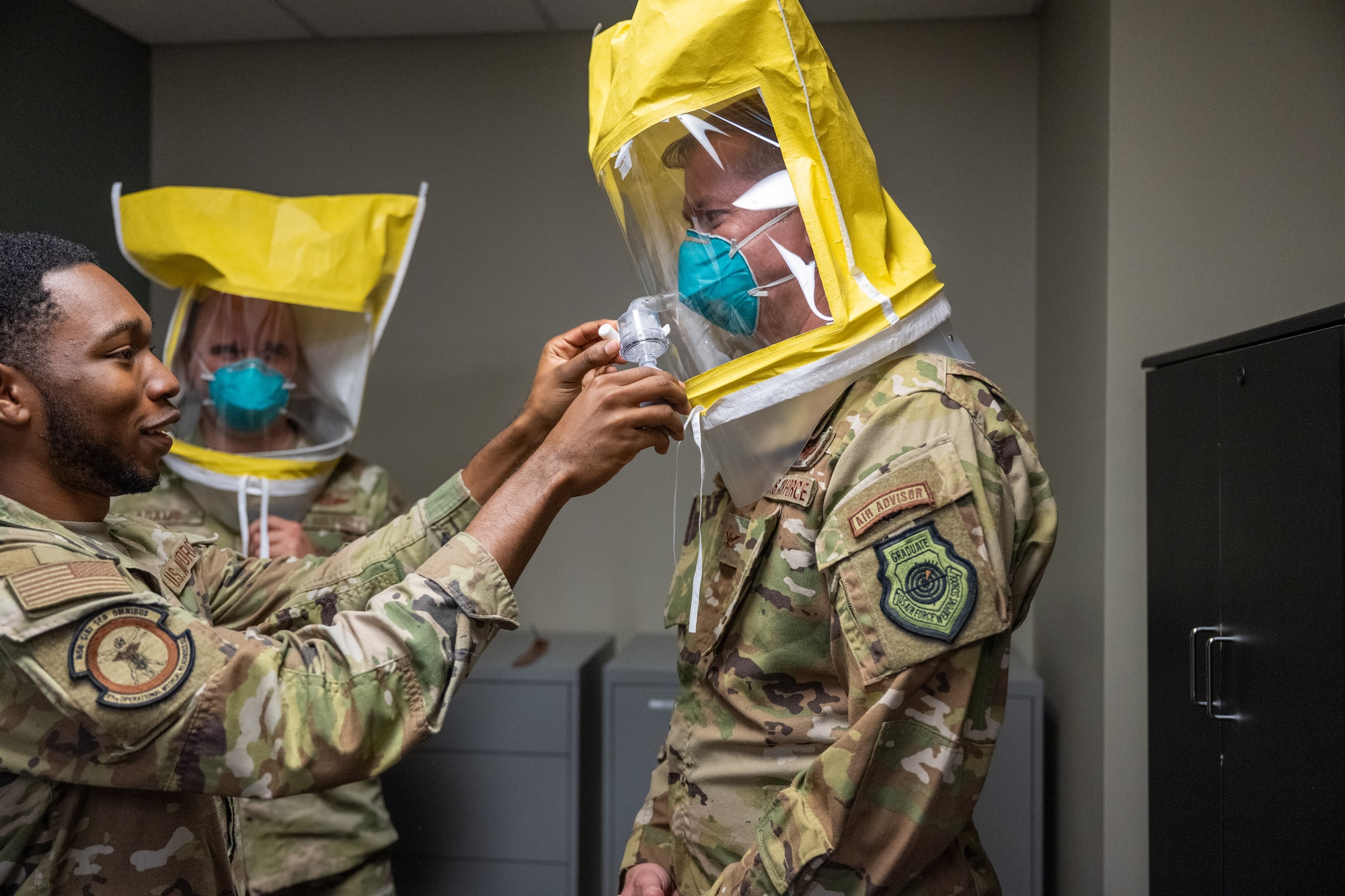 U.S. Air Force Col. Richard Kind, 97th Air Mobility Wing (AMW) commander, right, and Chief Master Sgt. Jonny Adams, 97th AMW command chief, center, are fitted for an N95 respirator by Airman 1st Class Kendarious Hester, Altus Medical Group Operational Medical Readiness Squadron bioenvironmental engineering technician, at Altus Air Force Base, Oklahoma, April 13, 2026. The demonstration highlighted the squadron’s role in providing occupational health, environmental health and radiation safety support across the installation. (U.S. Air Force photo by Airman 1st Class Nathan Langston)
