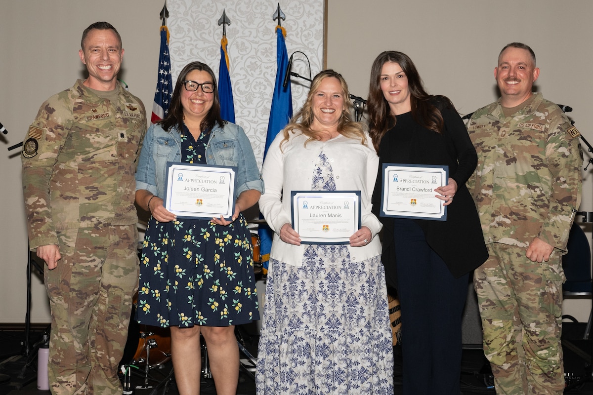 U.S. Air Force Lt. Col. Brian Crawford, 375th Operations Support Squadron commander, Joleen Garcia, Lauren Manis, and Brandi Crawford, 375th OSS key support liaisons, and Chief Master Sgt. Scott Lowrey, 375th OSS senior enlisted leader, pose during a Commander’s Key Support Program appreciation event at the Scott Event Center on Scott Air Force Base, Illinois, April 28, 2026.
