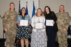 U.S. Air Force Lt. Col. Brian Crawford, 375th Operations Support Squadron commander, Joleen Garcia, Lauren Manis, and Brandi Crawford, 375th OSS key support liaisons, and Chief Master Sgt. Scott Lowrey, 375th OSS senior enlisted leader, pose during a Commander’s Key Support Program appreciation event at the Scott Event Center on Scott Air Force Base, Illinois, April 28, 2026.