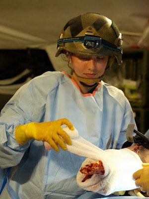 Hospital Corpsman 2nd Class Ella Semerad, surgical technologist, assigned to Expeditionary Resuscitative Surgical System (ERSS) 12, Navy Medicine Readiness and Training Command Camp Lejeune, North Carolina, applies a pressure dressing to a simulated wound during ERSS training at the Naval Expeditionary Medicine Warfighter Development Center, Camp Pendleton, California, March 17-26, 2026. Sailors trained on hemorrhage control techniques to increase survivability in combat environments. (U.S. Navy photo by Petty Officer 2nd Class Kwame Obengyeboah)