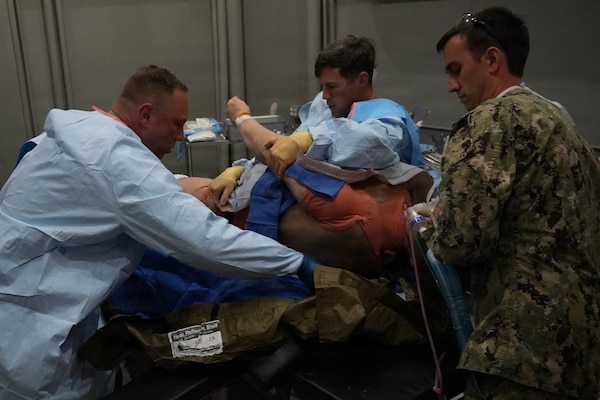 Cmdr. Ryan Schutt (left), surgeon, and Hospital Corpsman 2nd Class Ella Semerad (right), surgical technologist, assigned to Expeditionary Resuscitative Surgical System (ERSS) 12, Navy Medicine Readiness and Training Command Camp Lejeune, North Carolina, conduct a surgical procedure on a simulated casualty during ERSS training at the Naval Expeditionary Medicine Warfighter Development Center, Camp Pendleton, California, March 17-26, 2026. The high-fidelity training prepares Navy medical personnel to deliver lifesaving care in austere and contested environments. (U.S. Navy photo by Petty Officer 2nd Class Kwame Obengyeboah)