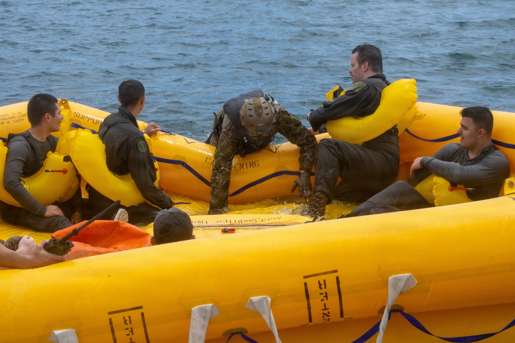 U.S. Air Force aircrew members climb into a raft during their water survival training.