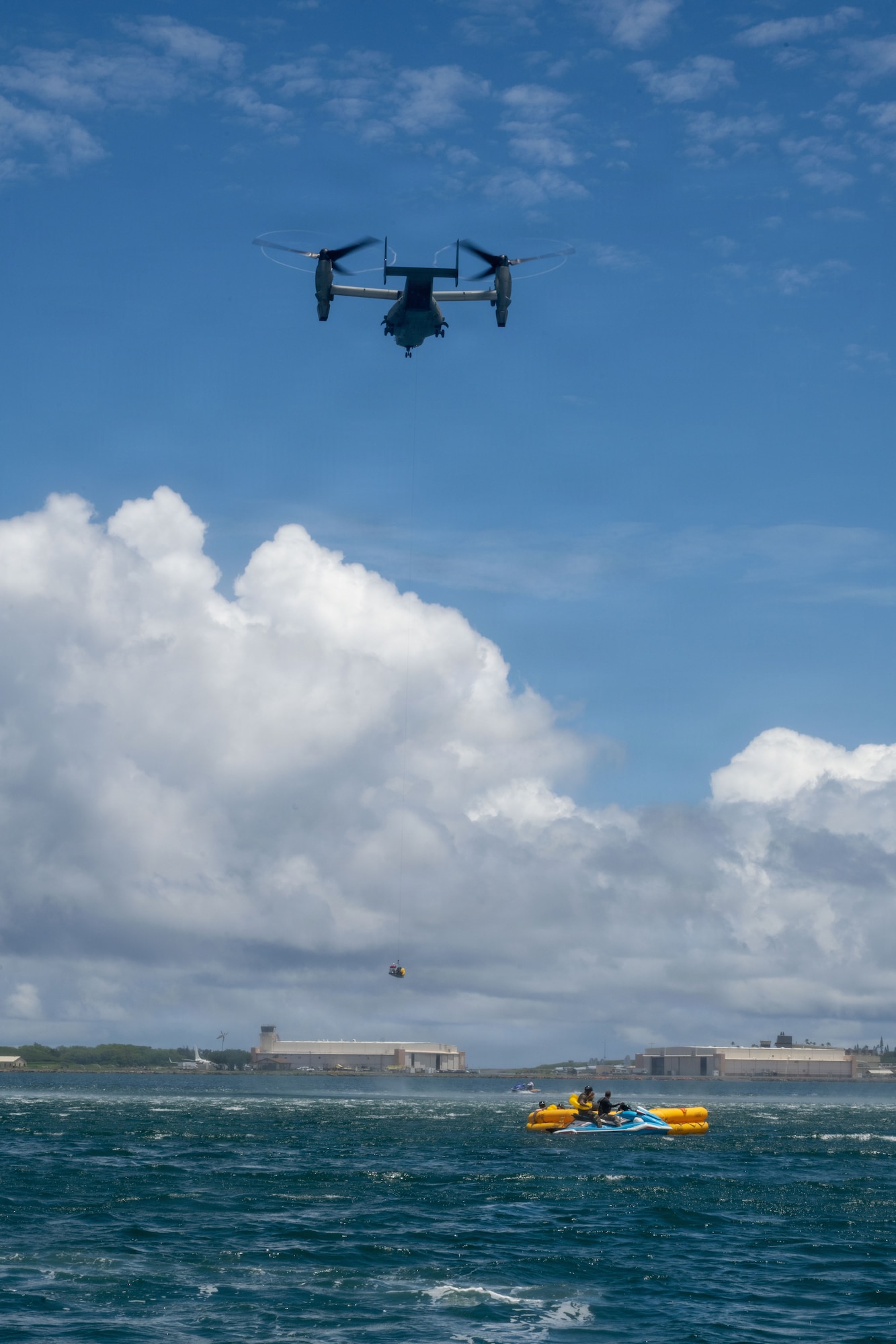 A U.S. Marine Corps MV-22 Osprey hoists up U.S. Air Force aircrew personnel during water survival training.