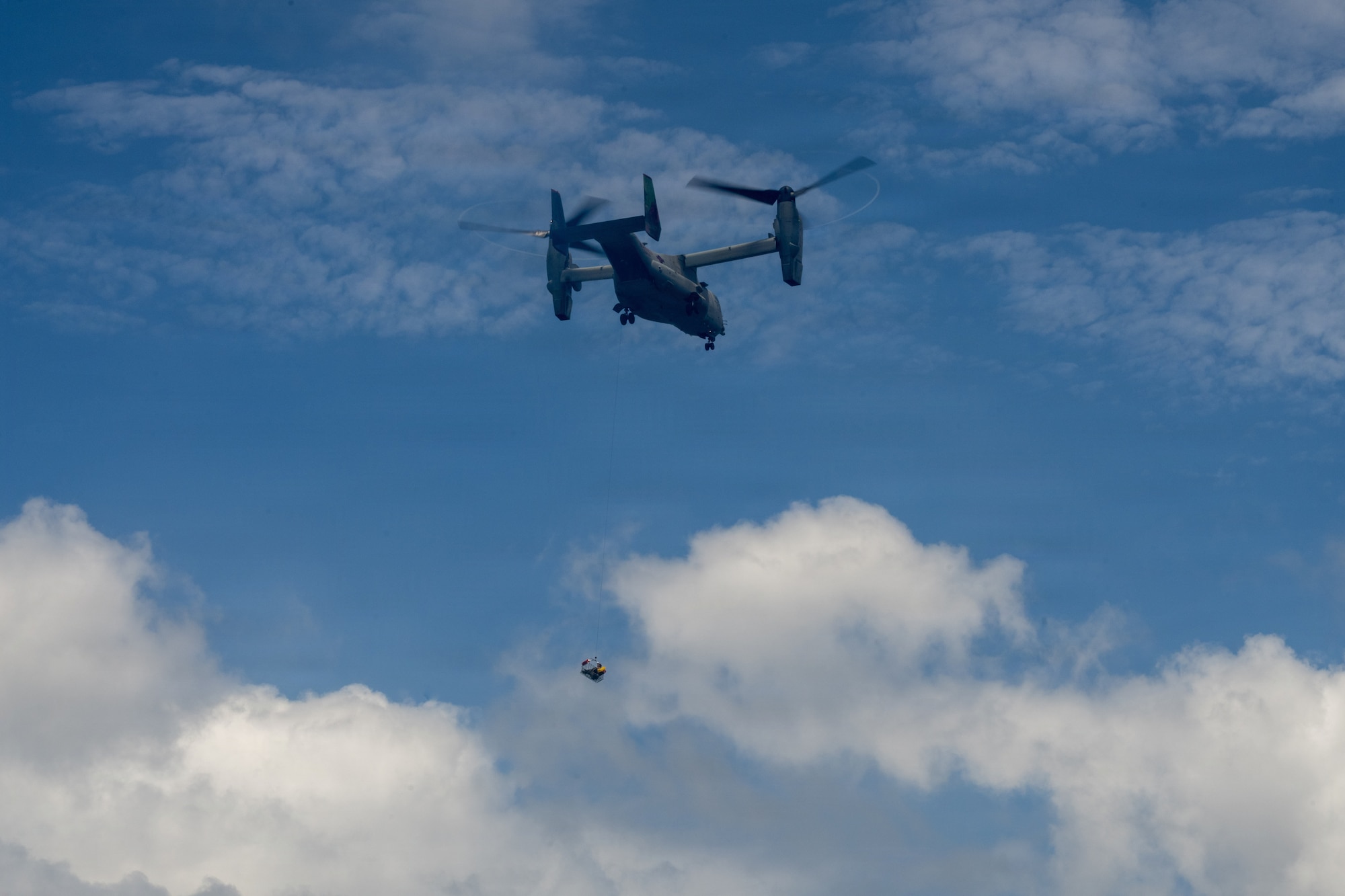 A U.S. Marine Corps MV-22 Osprey hoists up U.S. Air Force aircrew personnel during water survival training.