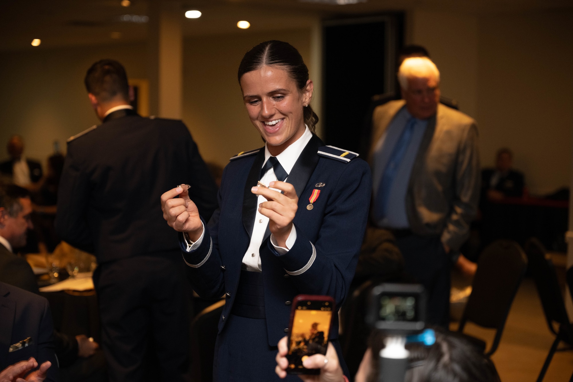 U.S. Air Force 2nd Lt. Jocelyn Ratzlaff, 47th Student Squadron student pilot, holds up their broken silver wings during the graduation ceremony of Class 26-09 at Laughlin Air Force Base, Texas, April 30, 2026. Graduating student pilots received silver wings as a symbol of successfully completing Undergraduate Pilot Training. (U.S. Air Force photo by Airman 1st Class Darryl Keith)