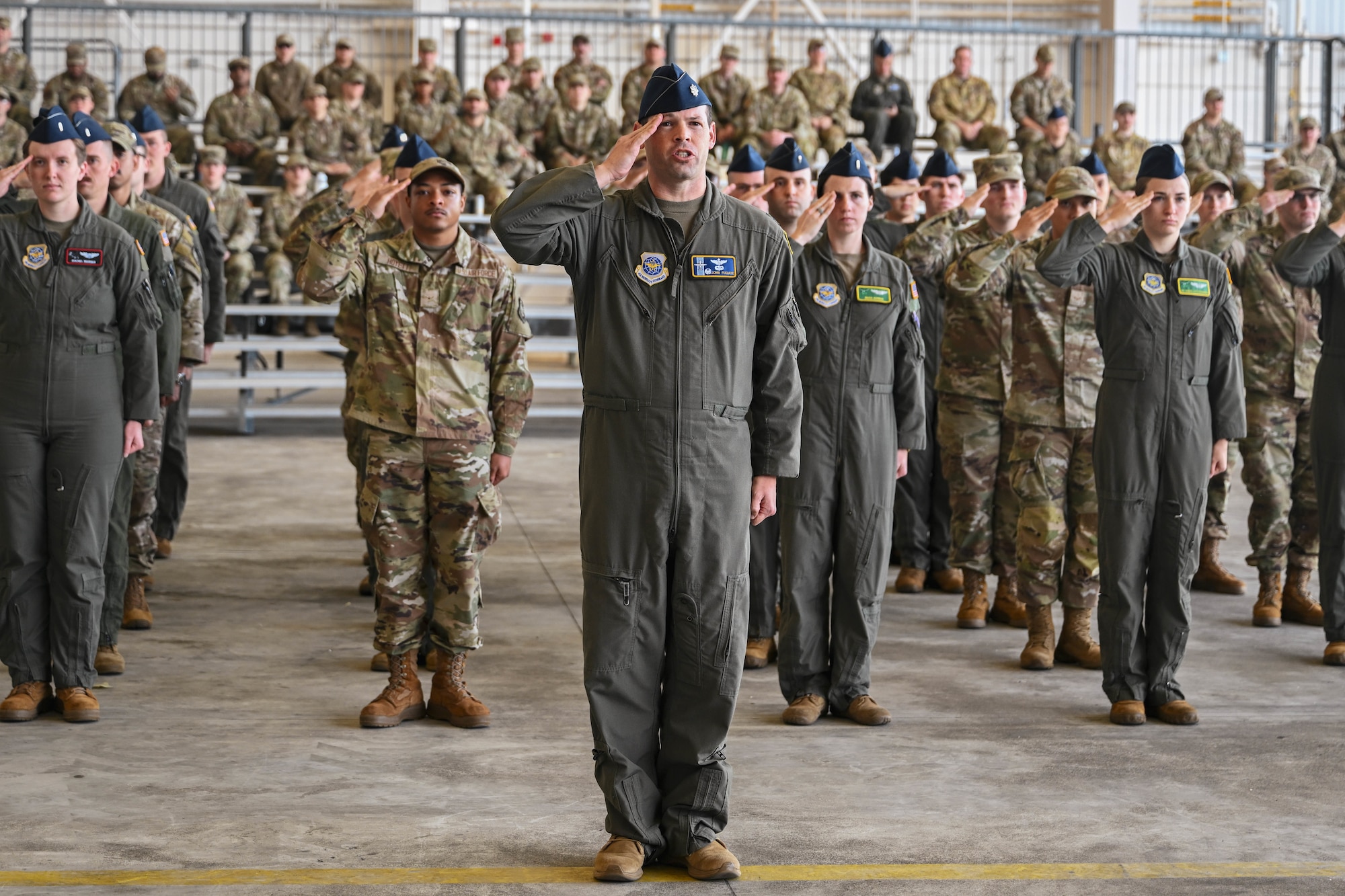 Airmen stand in formation rendering a salute.