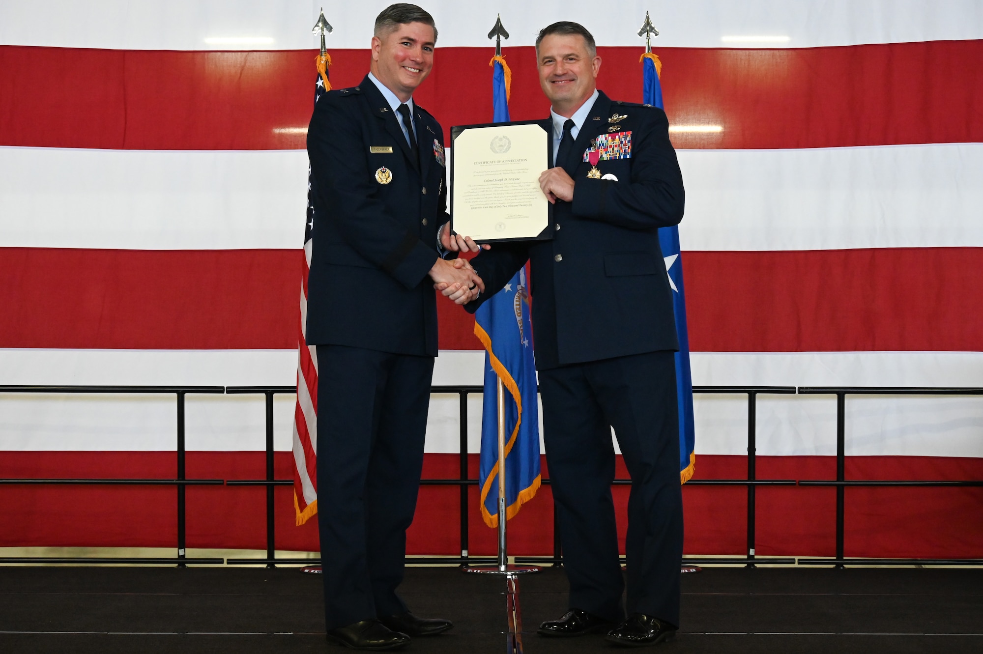 From left, U.S. Air Force Brig. Gen. David Fazenbaker, Headquarters Air Mobility Command Director of Strategy, Plans, Requirements and Programs, presents U.S. Air Force Col. Joseph McCane, 47th Operations Group commander, the Legion of Merit certificate during a retirement ceremony at Laughlin Air Force Base, Texas, May 1, 2026. Fazenbaker highlighted the assignments that made up the 35-year career of McCane. (U.S. Air Force photo by Airman 1st Class Kylie Rabb)