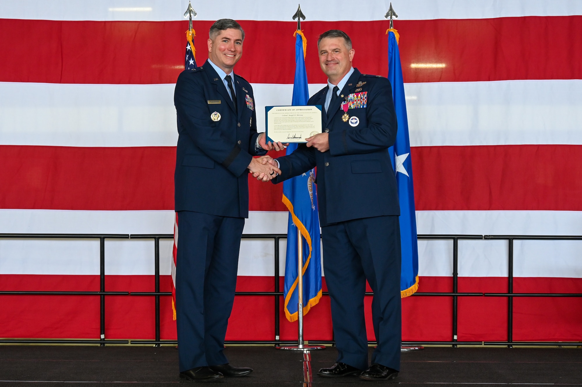 From left, U.S. Air Force Brig. Gen. David Fazenbaker, Headquarters Air Mobility Command Director of Strategy, Plans, Requirements and Programs, presents U.S. Air Force Col. Joseph McCane, 47th Operations Group commander, the Certificate of Appreciation during a retirement ceremony at Laughlin Air Force Base, Texas, May 1, 2026. The retirement ceremony celebrated the 35-year career of McCane. (U.S. Air Force photo by Airman 1st Class Kylie Rabb)